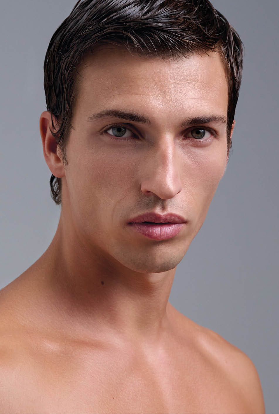 Persona adulta con cabello corto y oscuro mirando fijamente con expresi n neutral sobre un fondo gris. Descripci n generada con IA