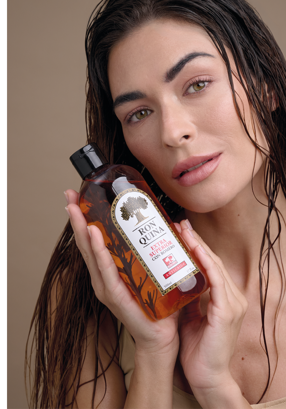 Persona con cabello mojado sostiene cerca del rostro una botella de champ o gel etiquetada como “Ron Quina Extra Superior".  Descripci n generada con IA