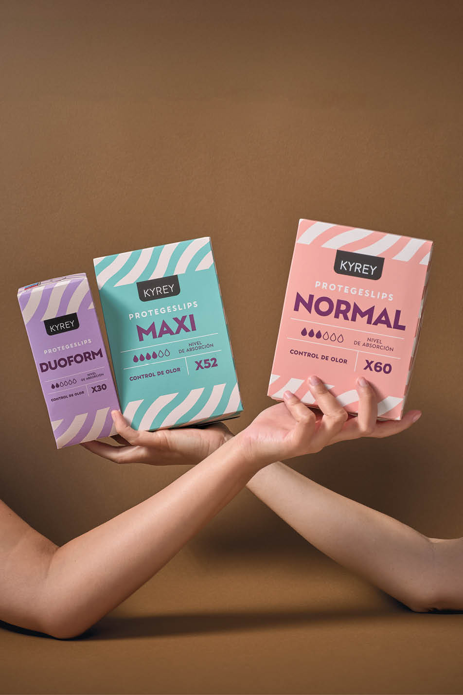 Dos personas extienden sus brazos para sostener tres cajas de protectores labiales de diferentes tama os y colores sobre un fondo marr n. Descripci n generada con IA