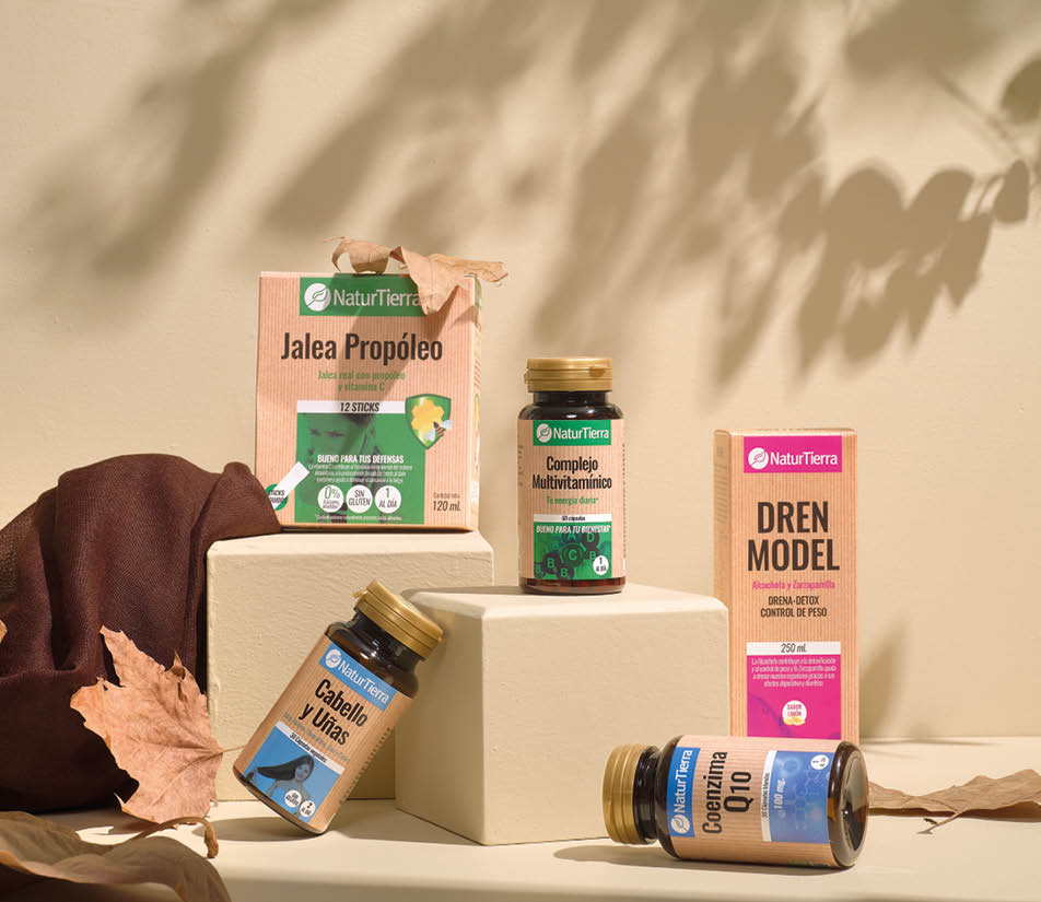 Suplementos naturales de la marca NaturTierra organizados sobre cubos blancos con hojas secas y fondo beige. Descripci n generada con IA