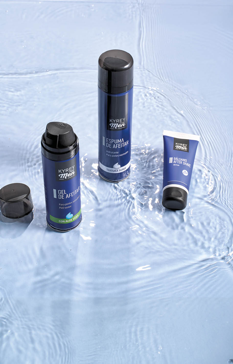 Tres productos de cuidado personal para afeitar sobre una superficie con agua y reflejos, con envases en tonos azul y negro. Descripci n generada con IA