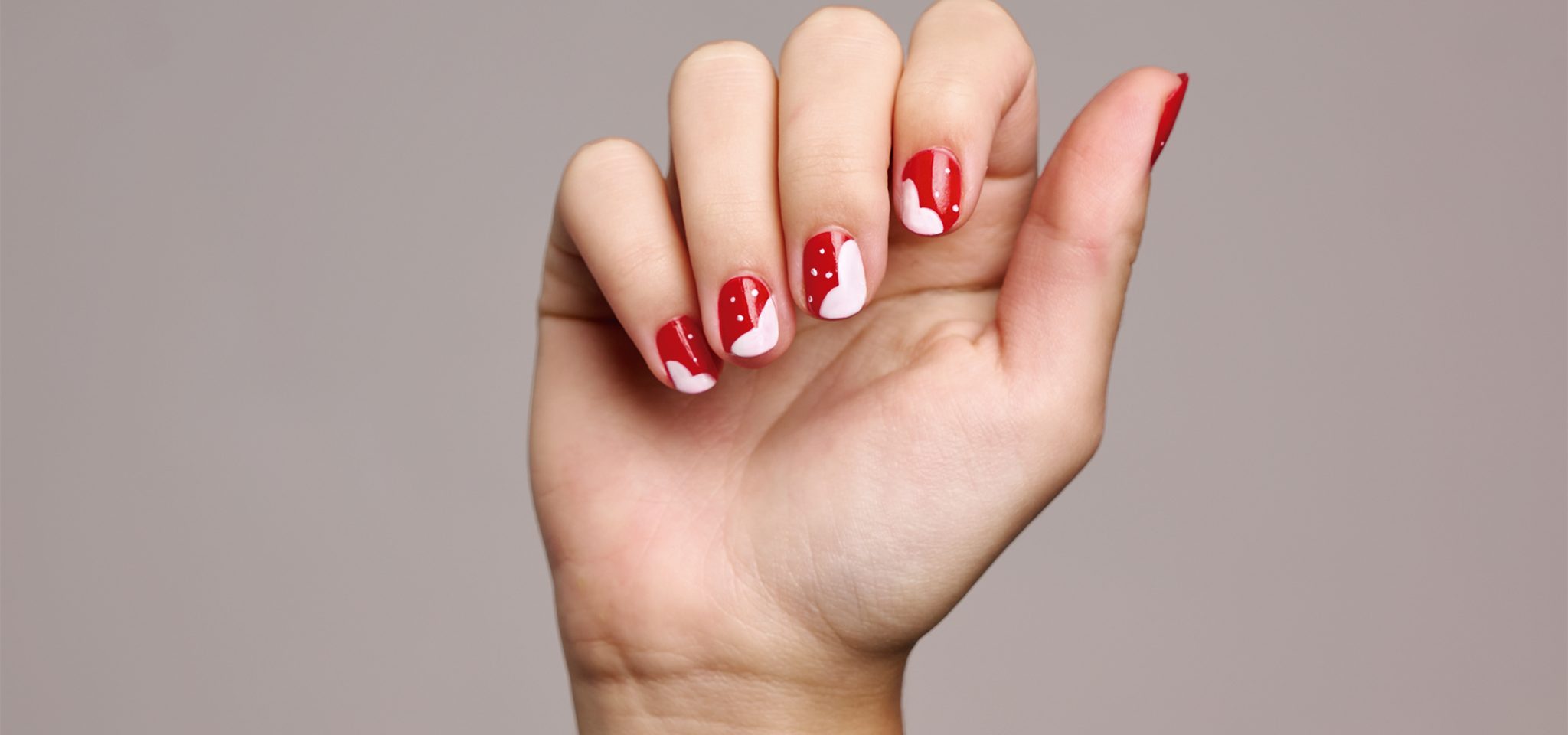 uñas rojas con corazones blancos